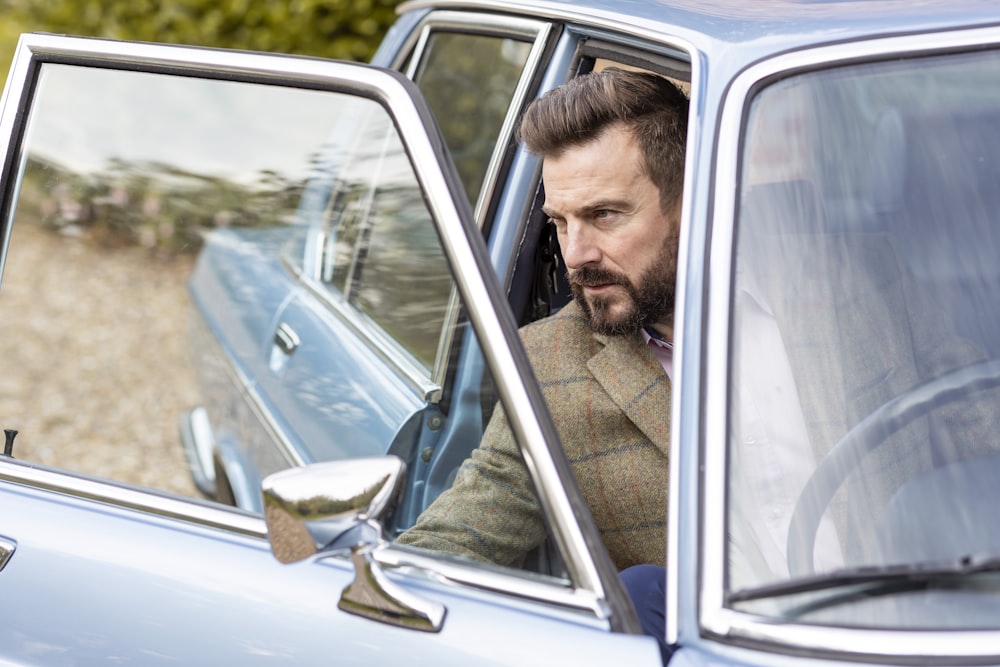 a man sitting in a car looking out the window