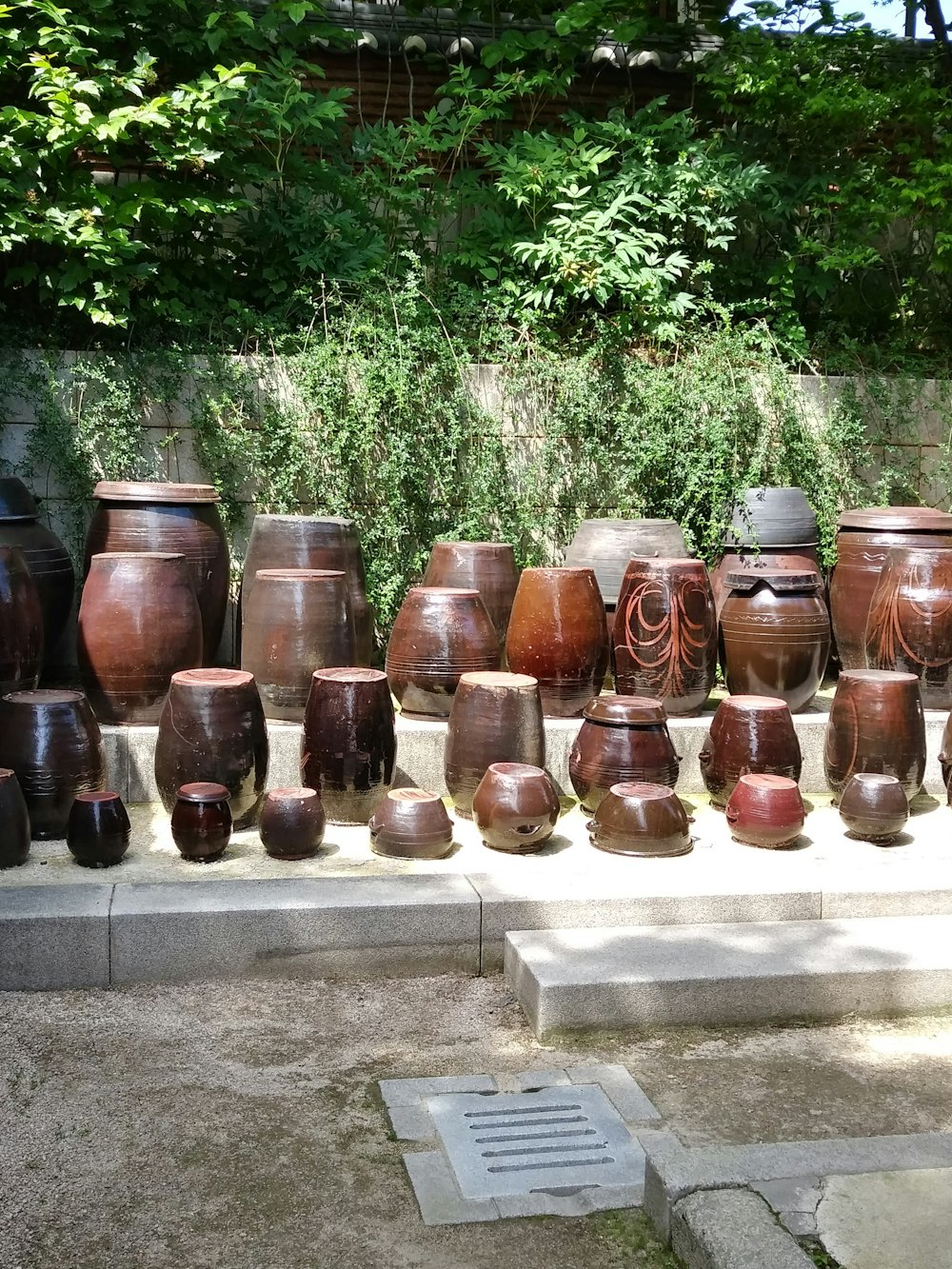 a bunch of vases are lined up outside