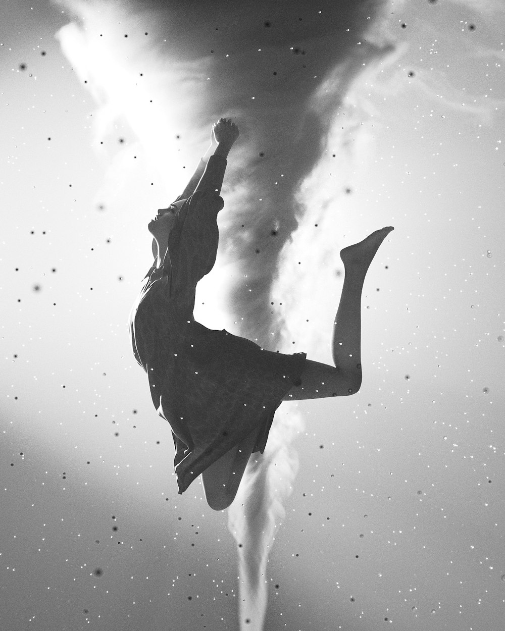 a black and white photo of a woman floating in the air