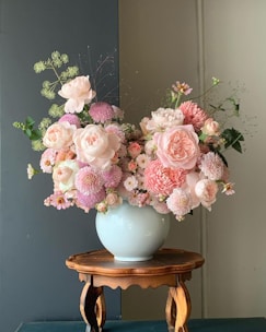 a blue vase filled with pink and white flowers