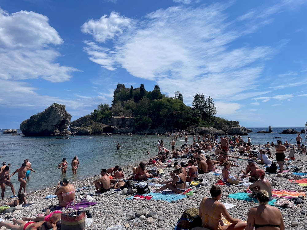 a group of people sitting on top of a sandy beach