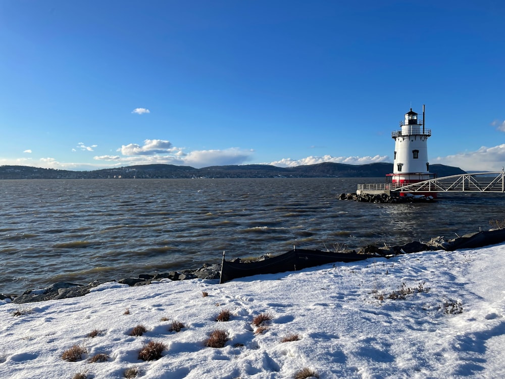 a light house sitting on top of a snow covered shore