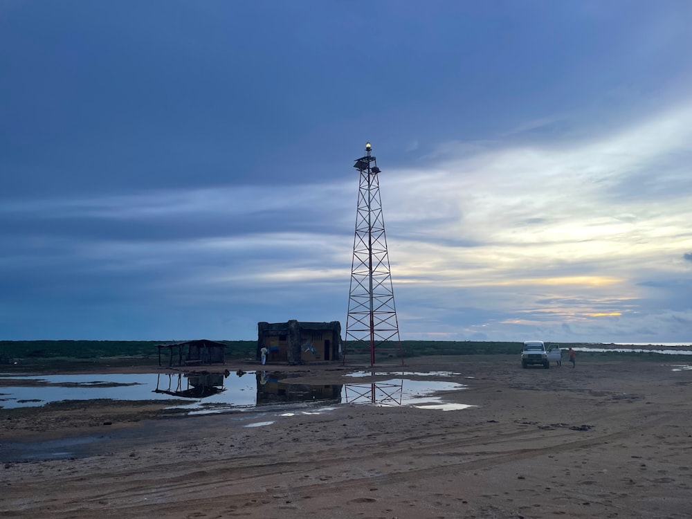 una torre alta sentada en la cima de una playa de arena