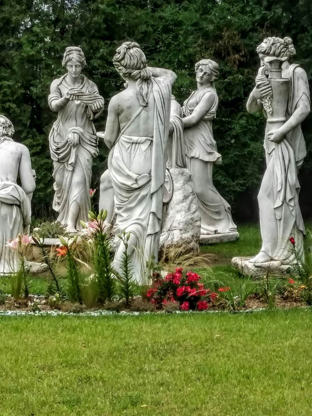 a group of statues in a grassy area