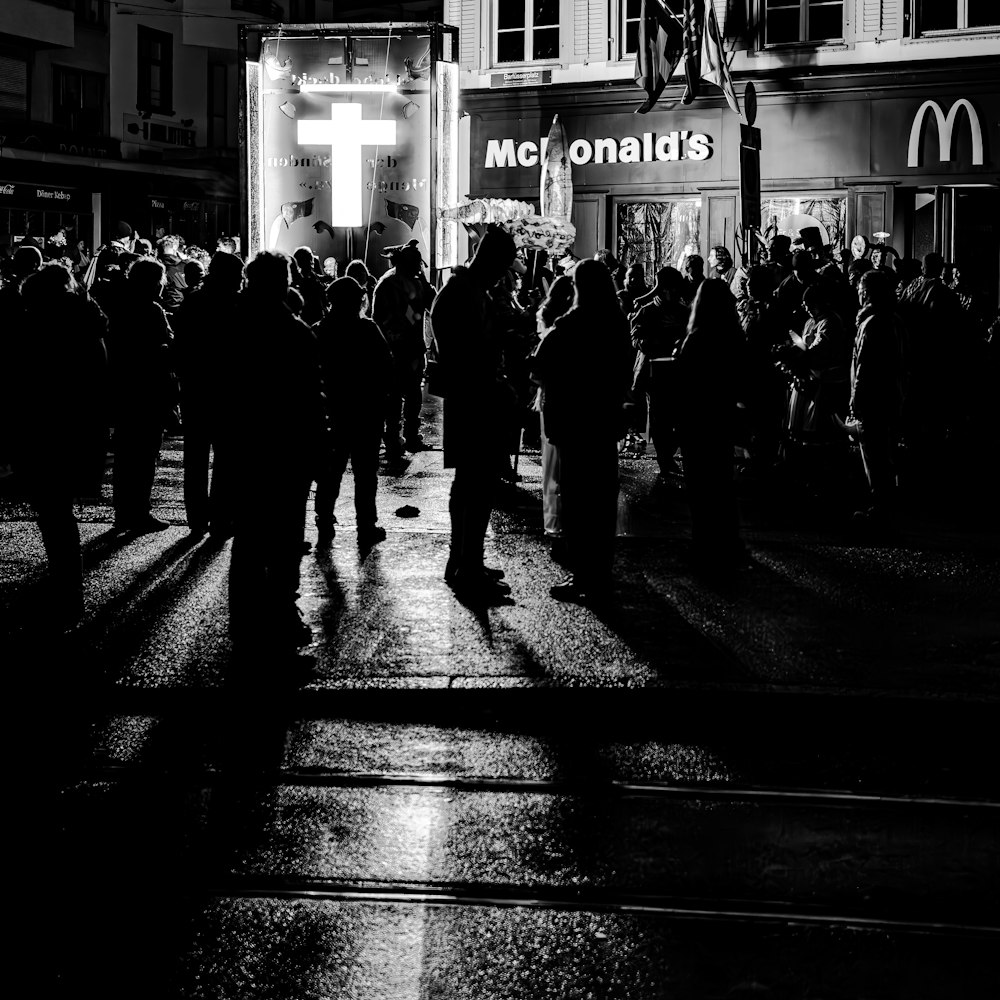 a black and white photo of a crowd of people outside a mcdonald's