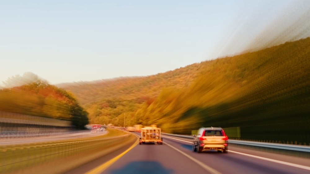 a blurry photo of a car and a truck on a highway