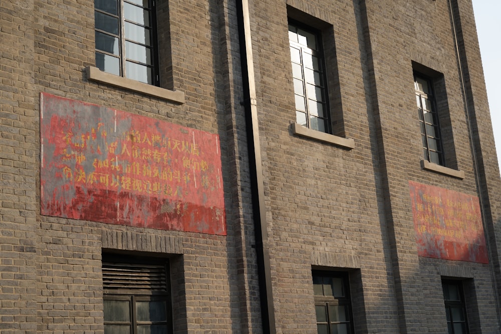 a brick building with two windows and a sign on the side