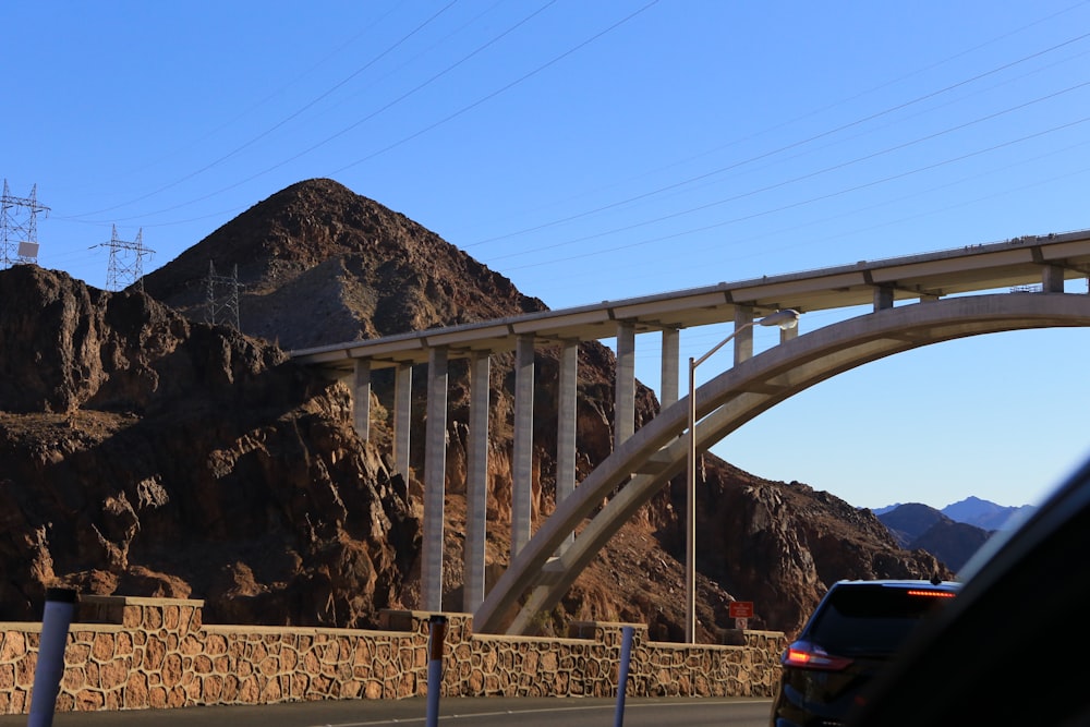 a bridge over a road with a mountain in the background