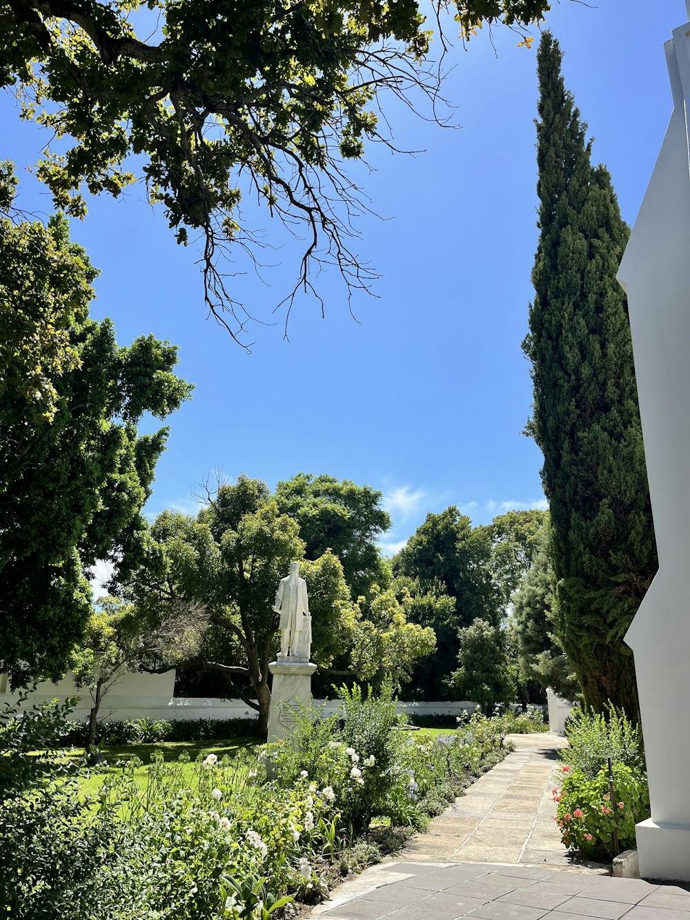 une statue d’un homme dans un parc entouré d’arbres