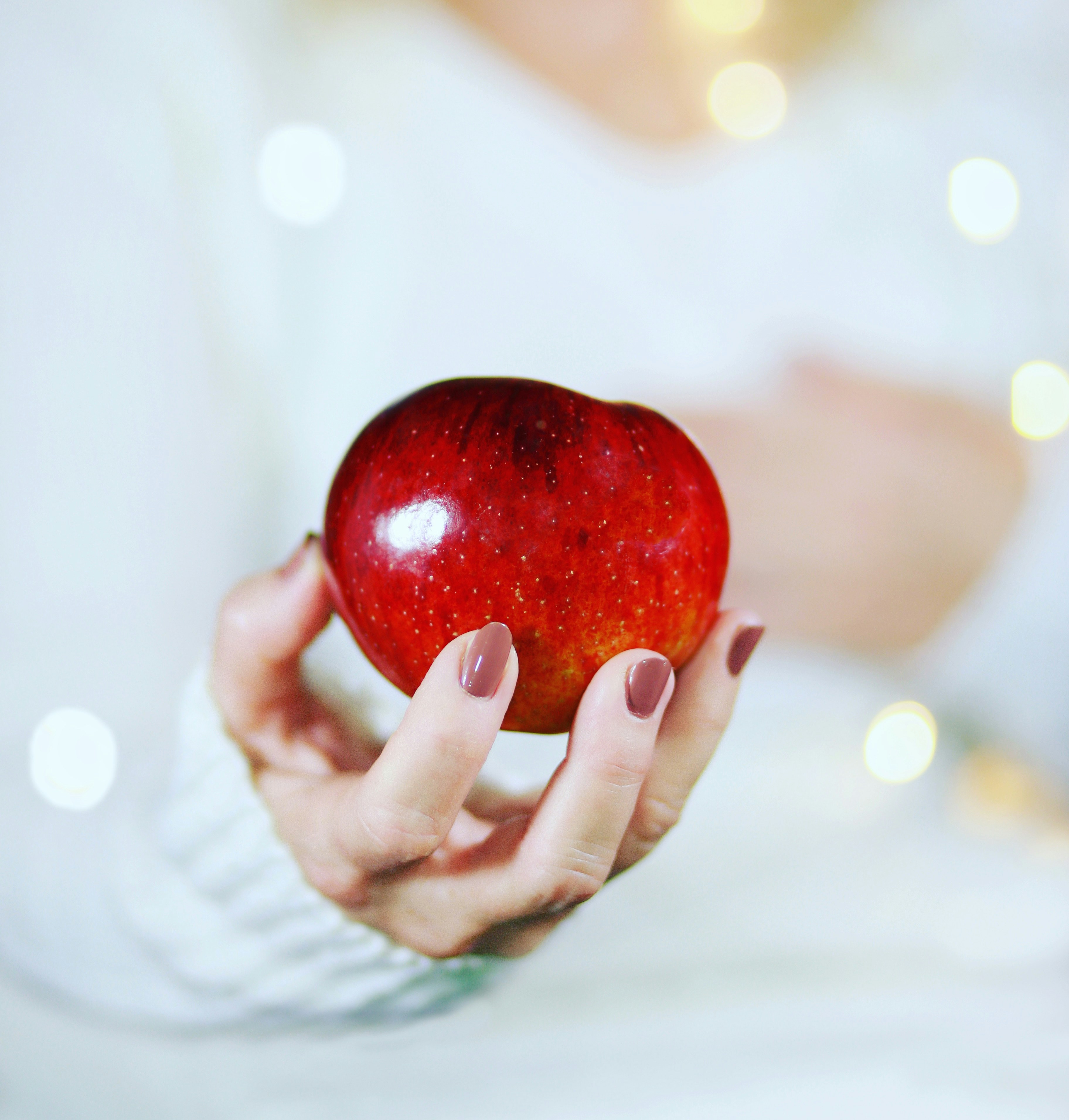 Woman holding a red apple representing heart-healthy nutrition