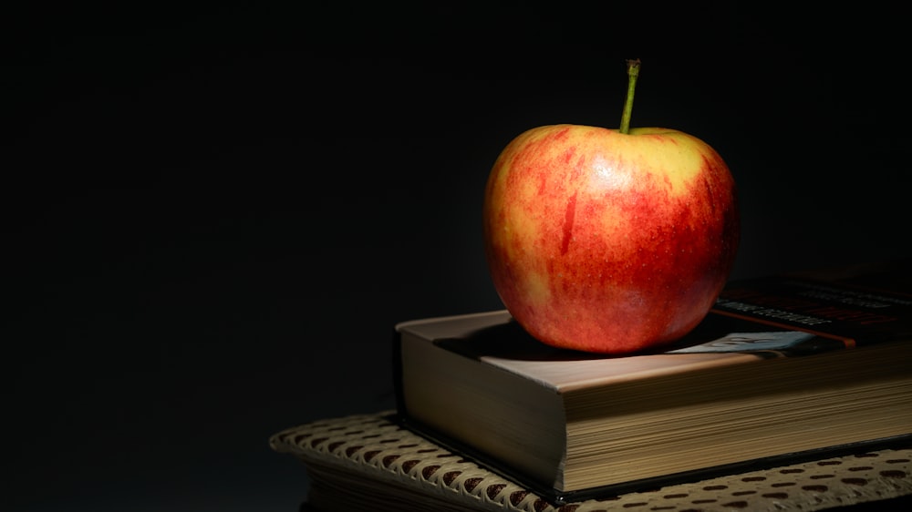 a red apple sitting on top of a book