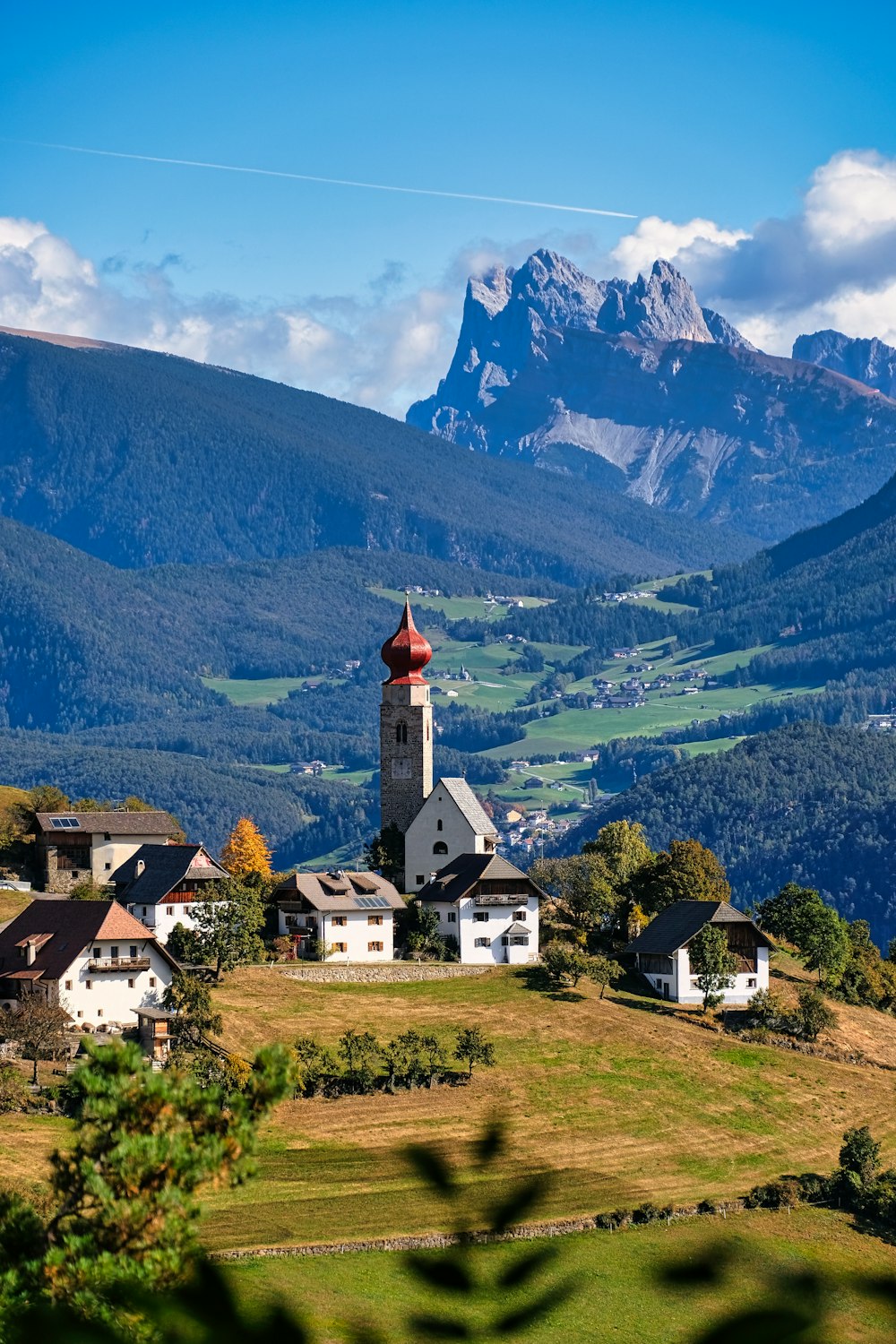 a church on a hill with mountains in the background