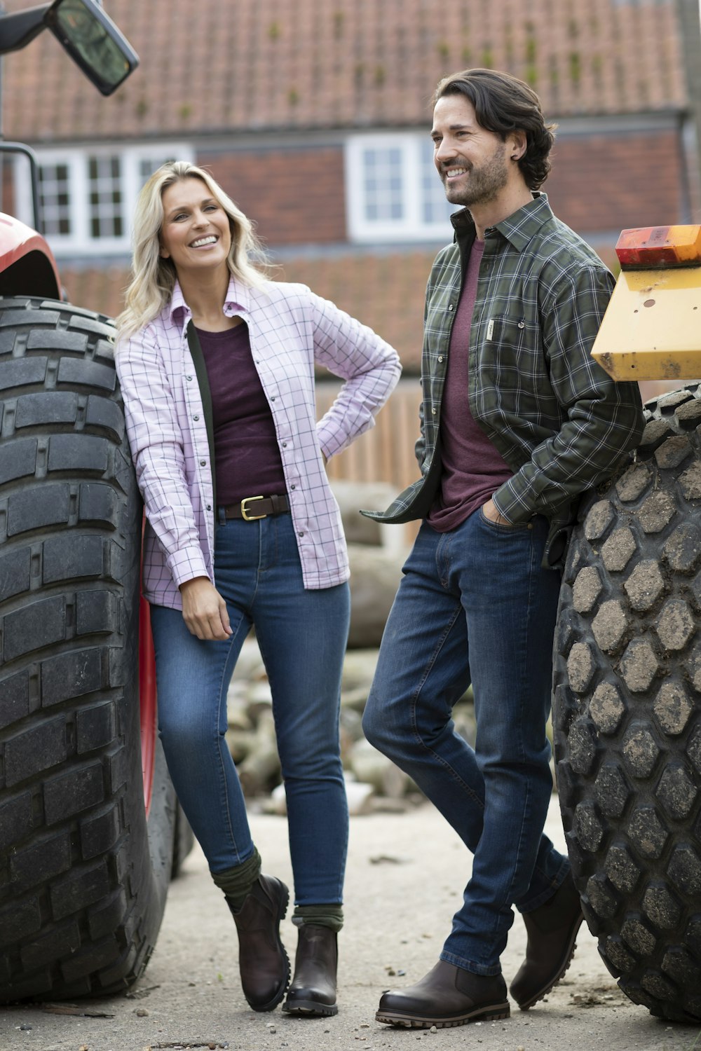 a man and a woman standing next to a tractor