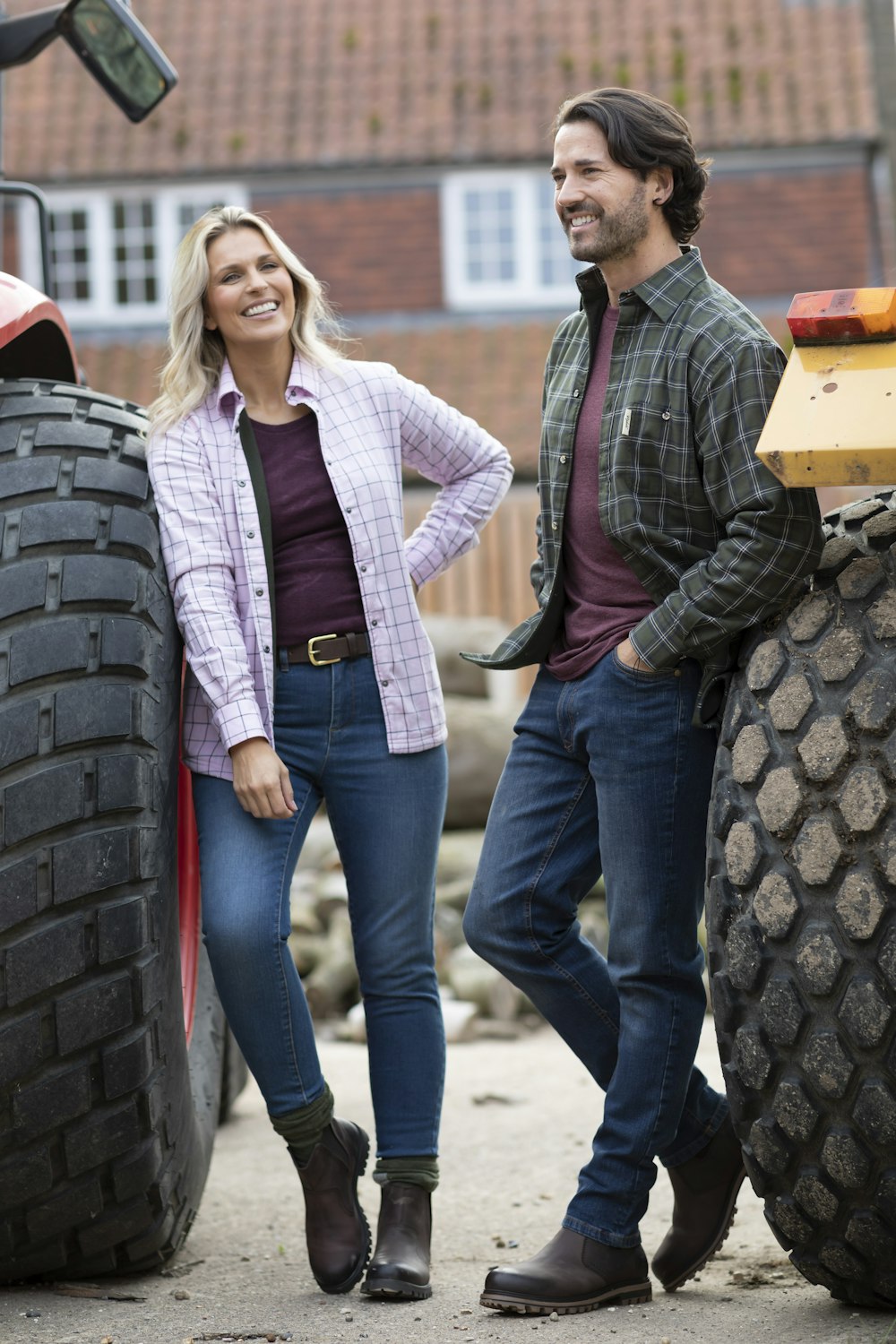 Un hombre y una mujer de pie junto a un tractor