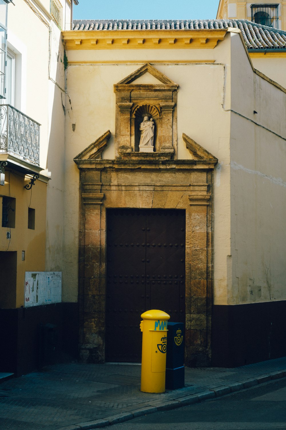 a yellow trash can sitting in front of a building
