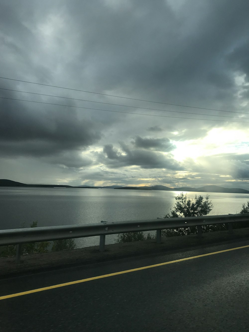 a car driving down a road next to a body of water