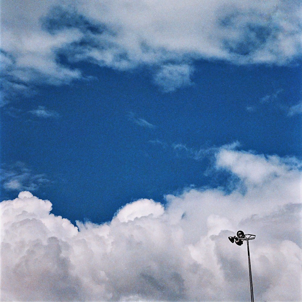 a street light in front of a cloudy blue sky