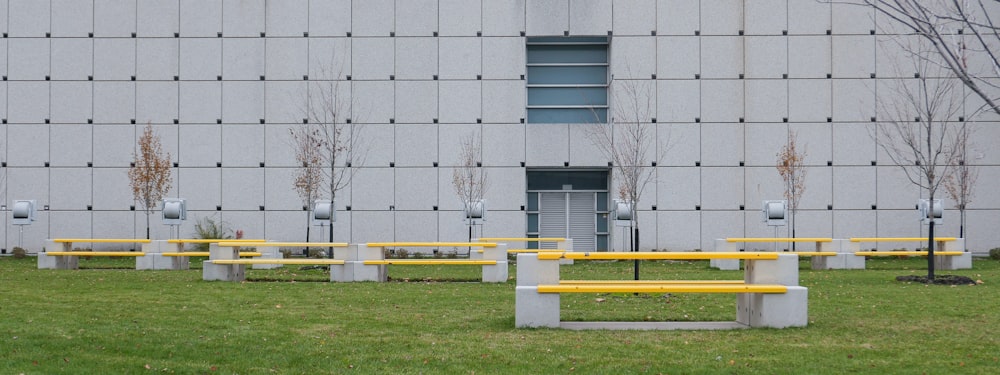 a row of yellow benches sitting in front of a building