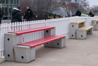 a couple of benches sitting next to a white fence