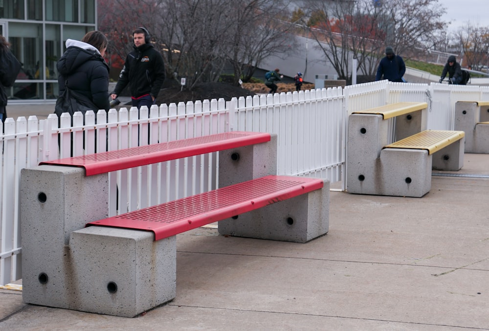 a couple of benches sitting next to a white fence