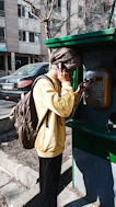 a person standing next to a pay phone