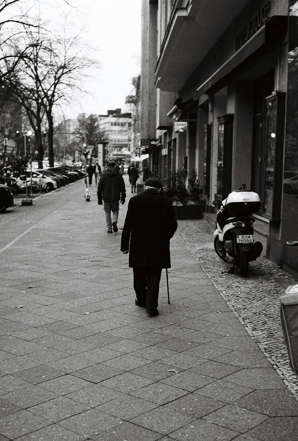 Una foto en blanco y negro de un hombre caminando por una acera