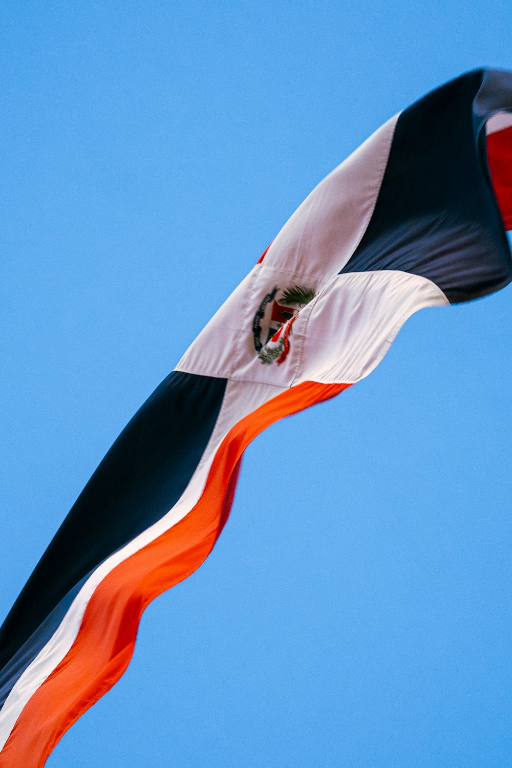 a flag flying in the air with a blue sky behind it