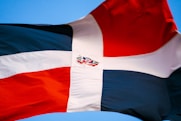 a red white and blue flag flying in the sky
