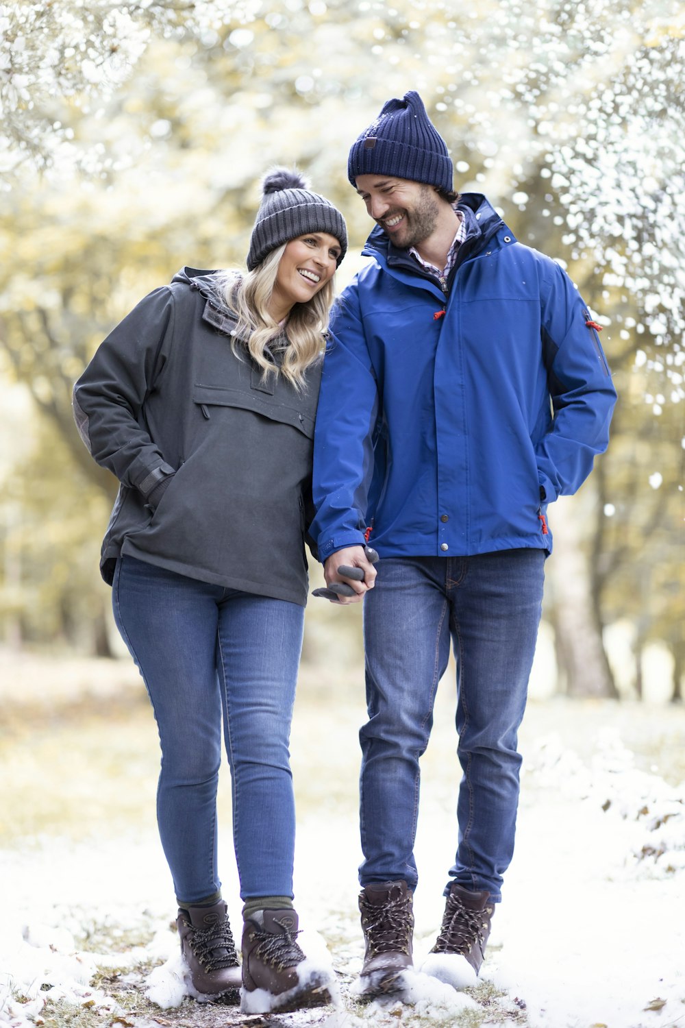 a man and a woman holding hands in the snow