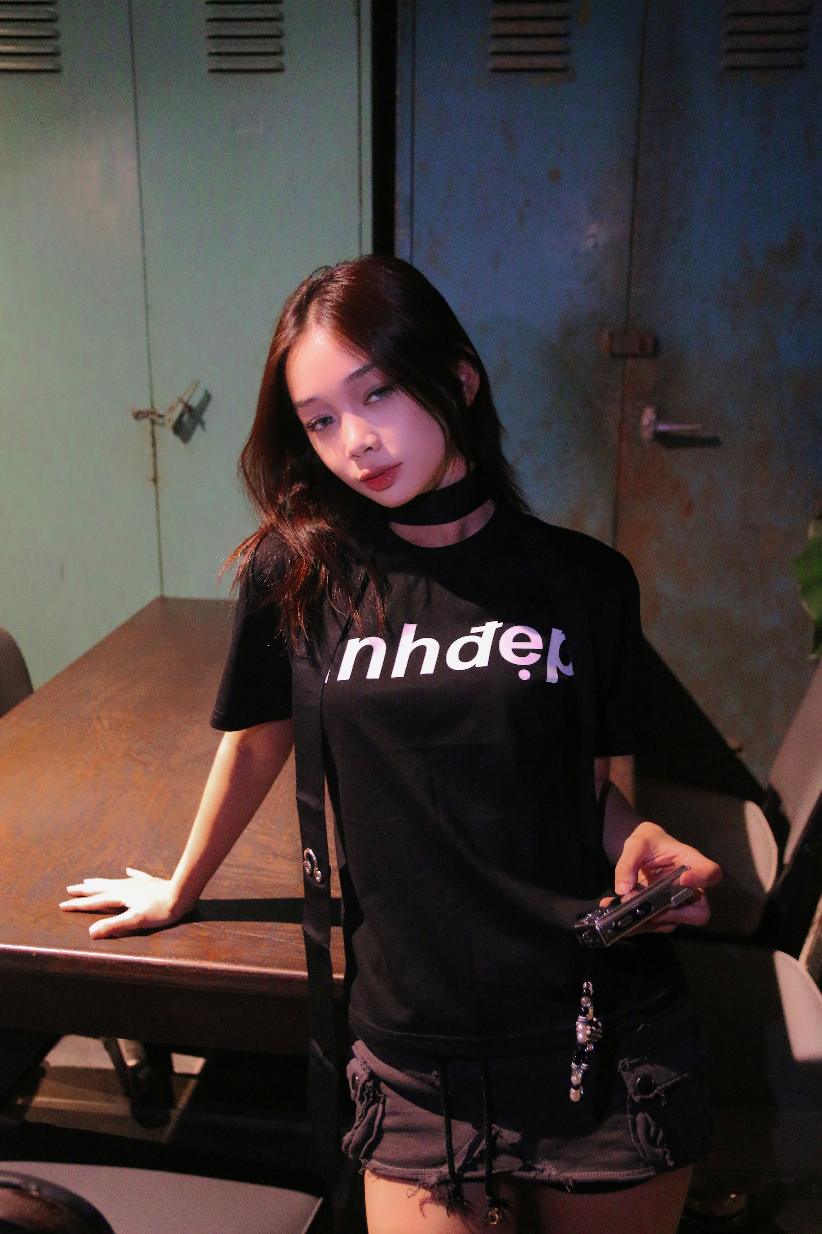 携帯電話を持ってテーブルの前に立つ女性