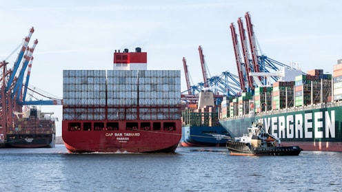 a large cargo ship in a harbor with other ships in the background