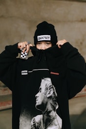 a person wearing a black hoodie with a picture of a man on it