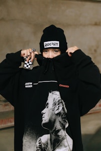 a person wearing a black hoodie with a picture of a man on it