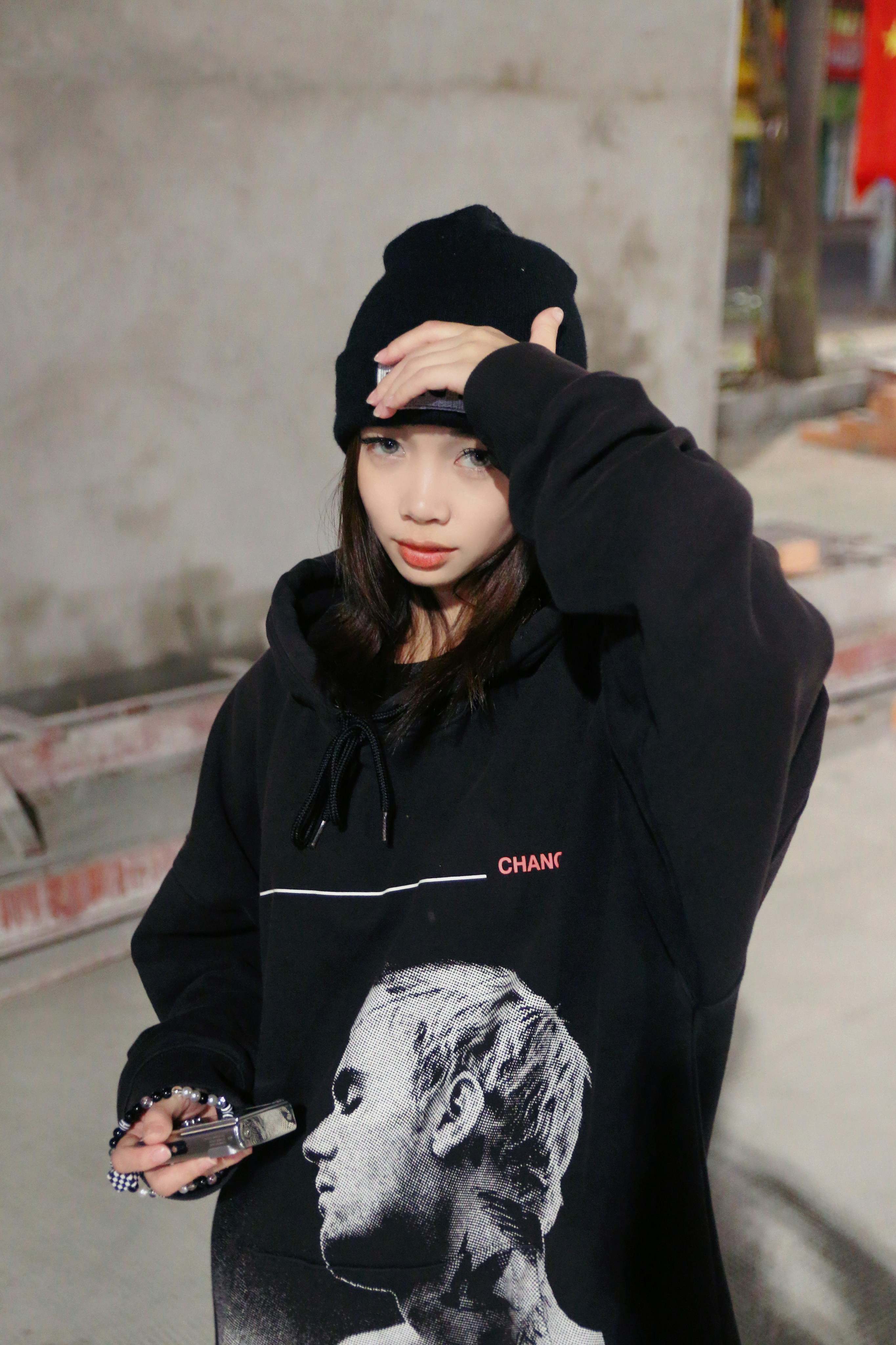 a woman wearing a black hoodie with a picture of a man on it