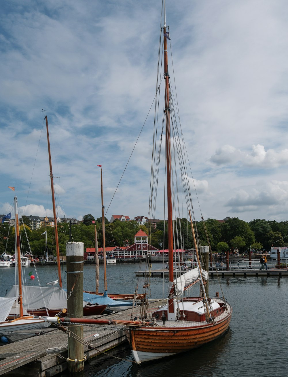 a sailboat docked at a pier with other boats