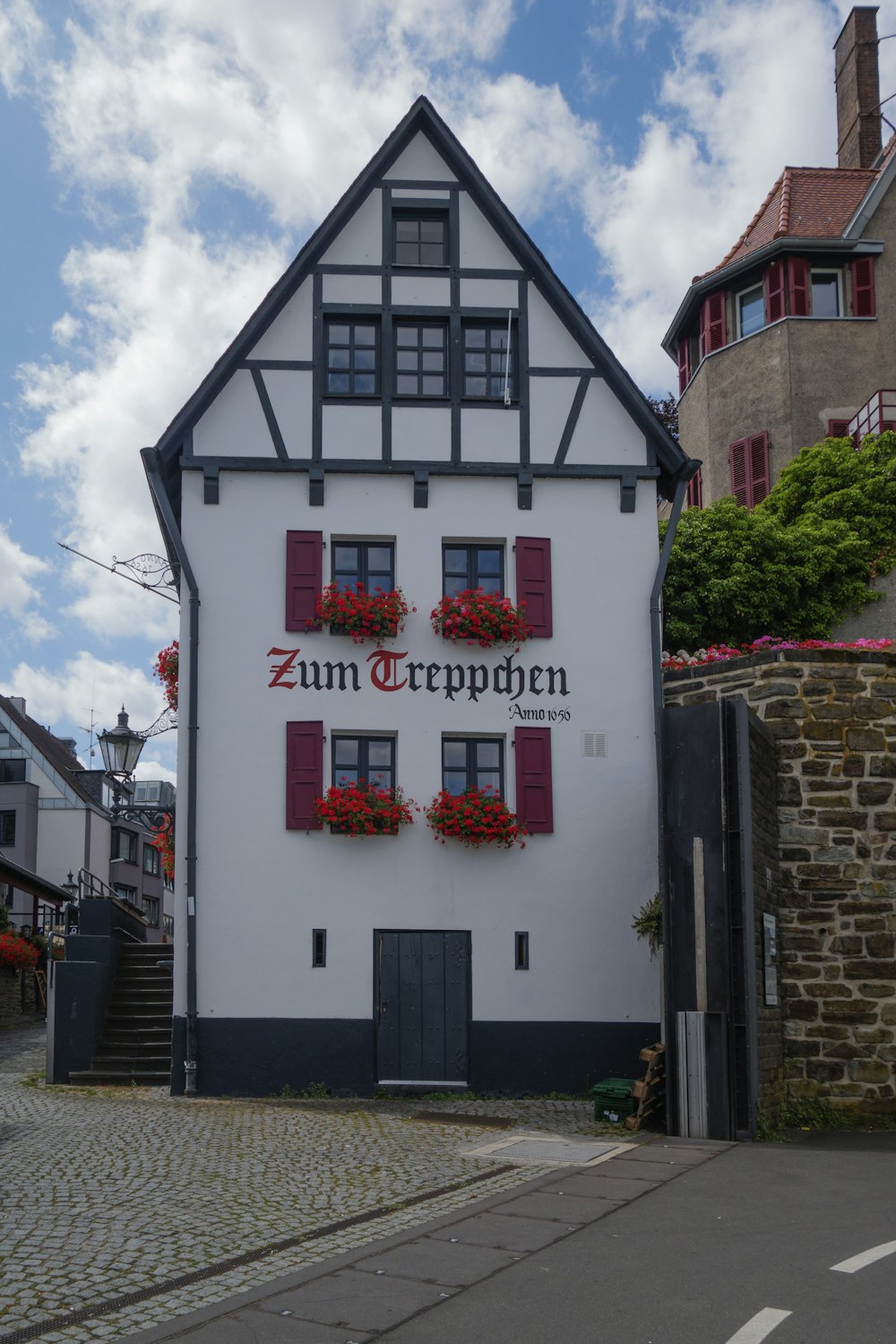 a white and black building with red shutters