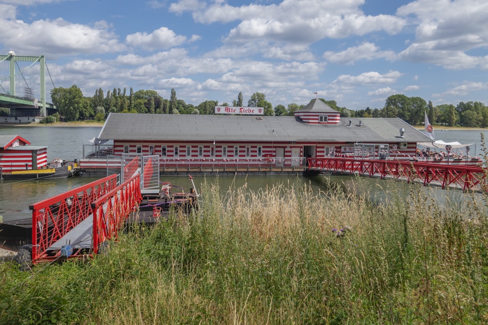 a red and white boat dock with a red bridge