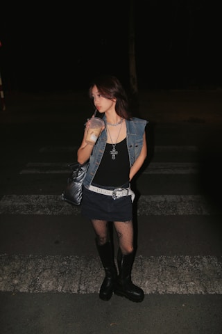 a woman standing on a street at night