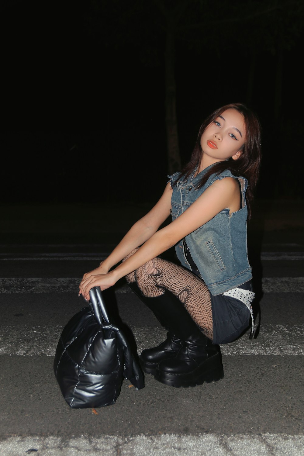 a woman sitting on the ground with a bag