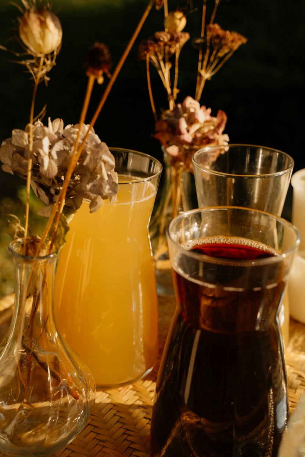 a table topped with vases filled with flowers and drinks