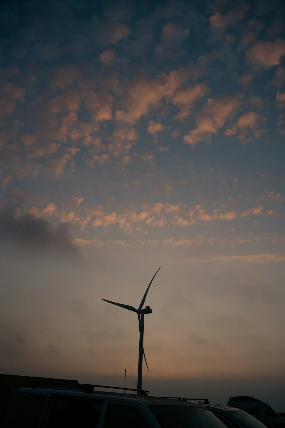 a wind turbine on top of a car in a parking lot