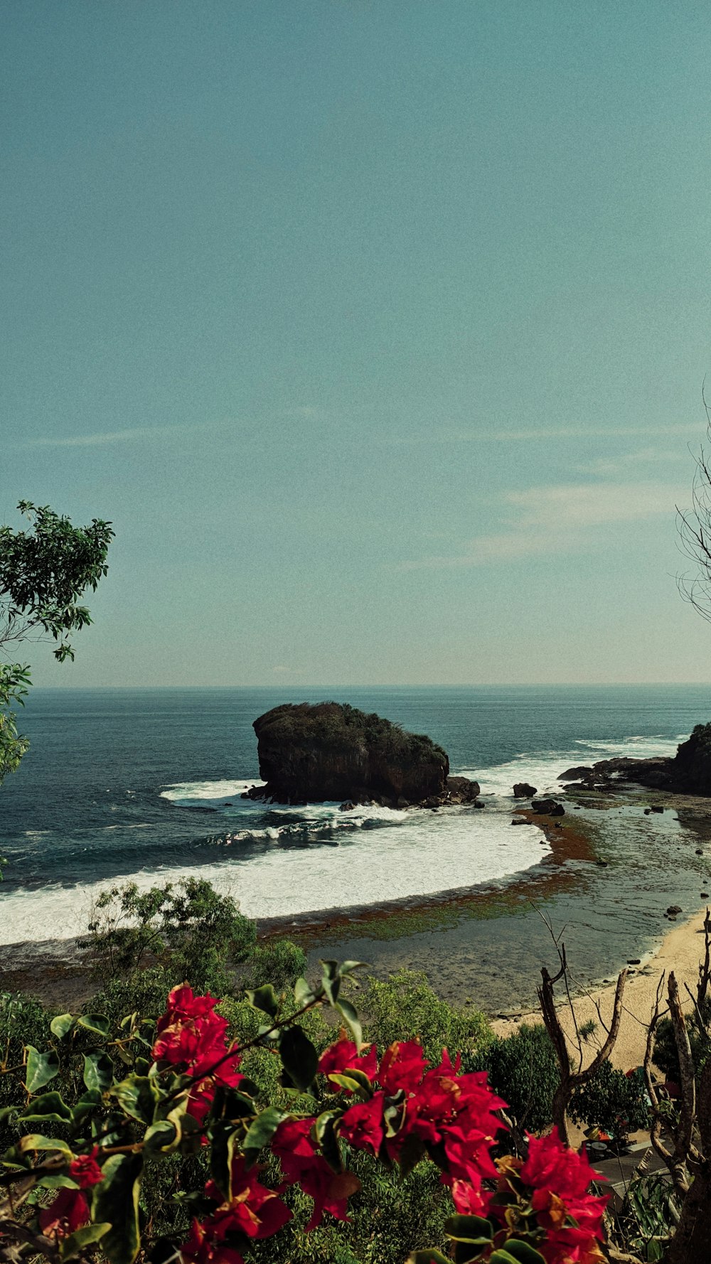 a view of a beach with a rock outcropping