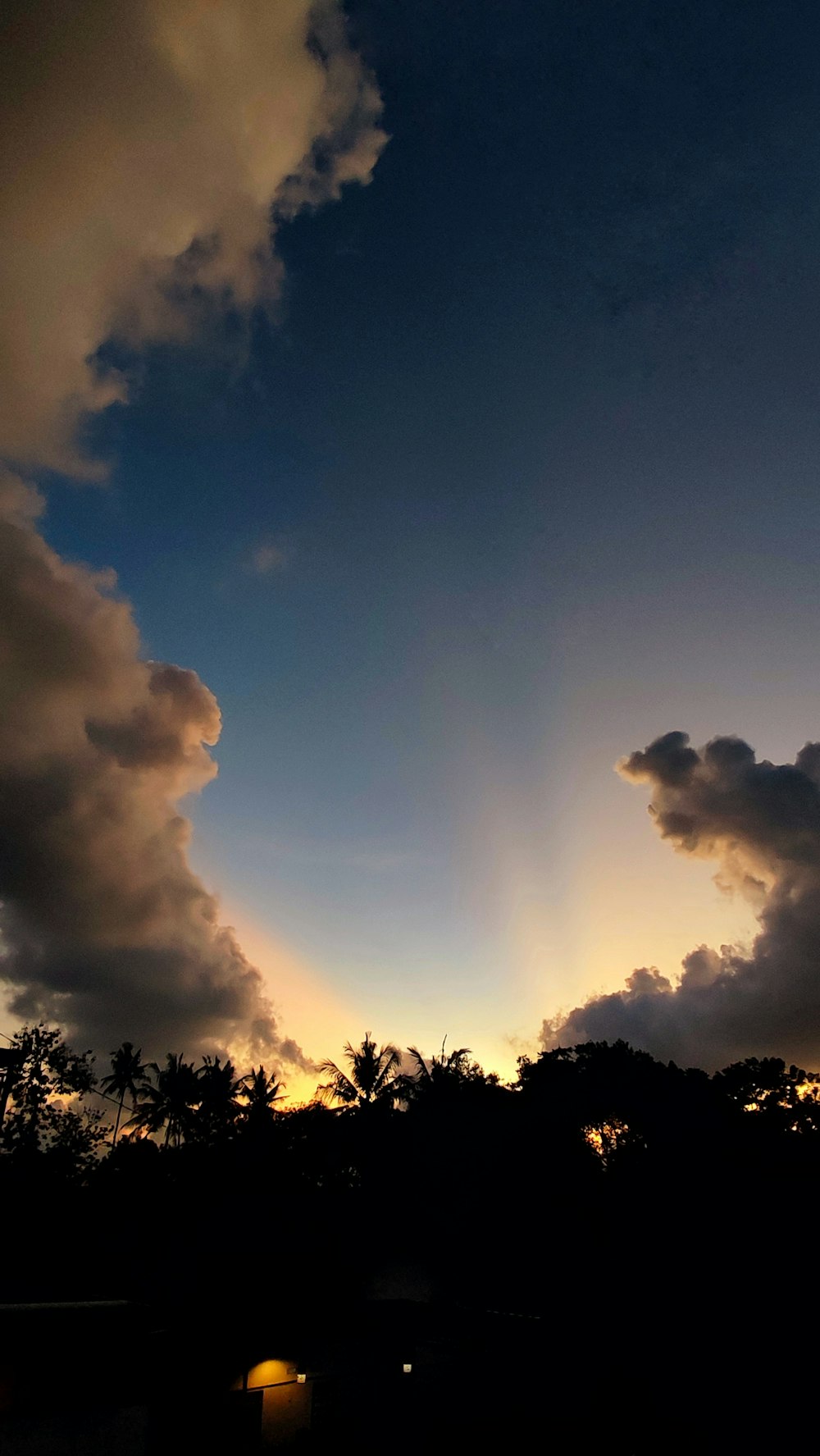 the sun is setting behind a cloud filled sky