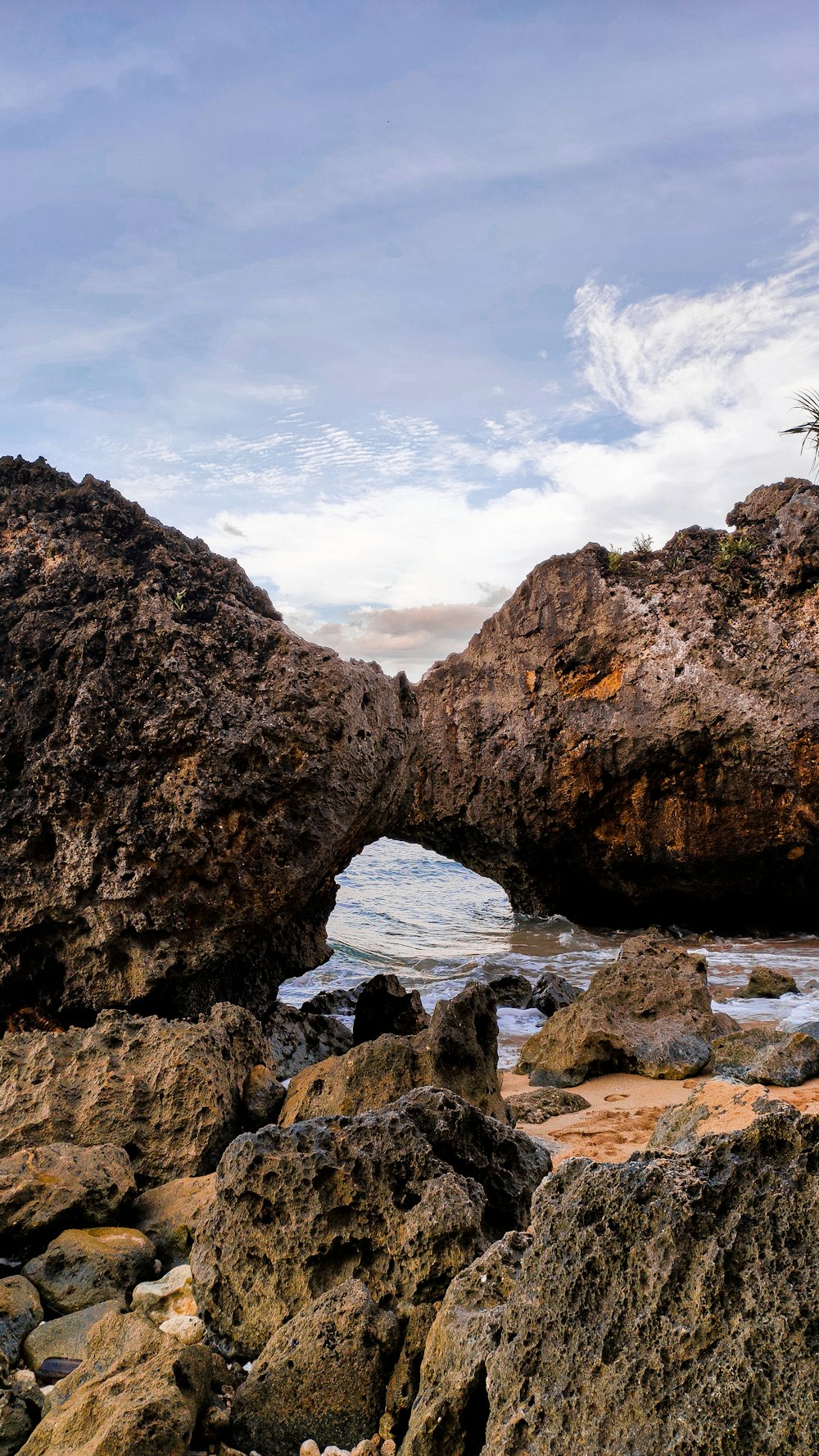a rocky beach with a small arch in the middle of it
