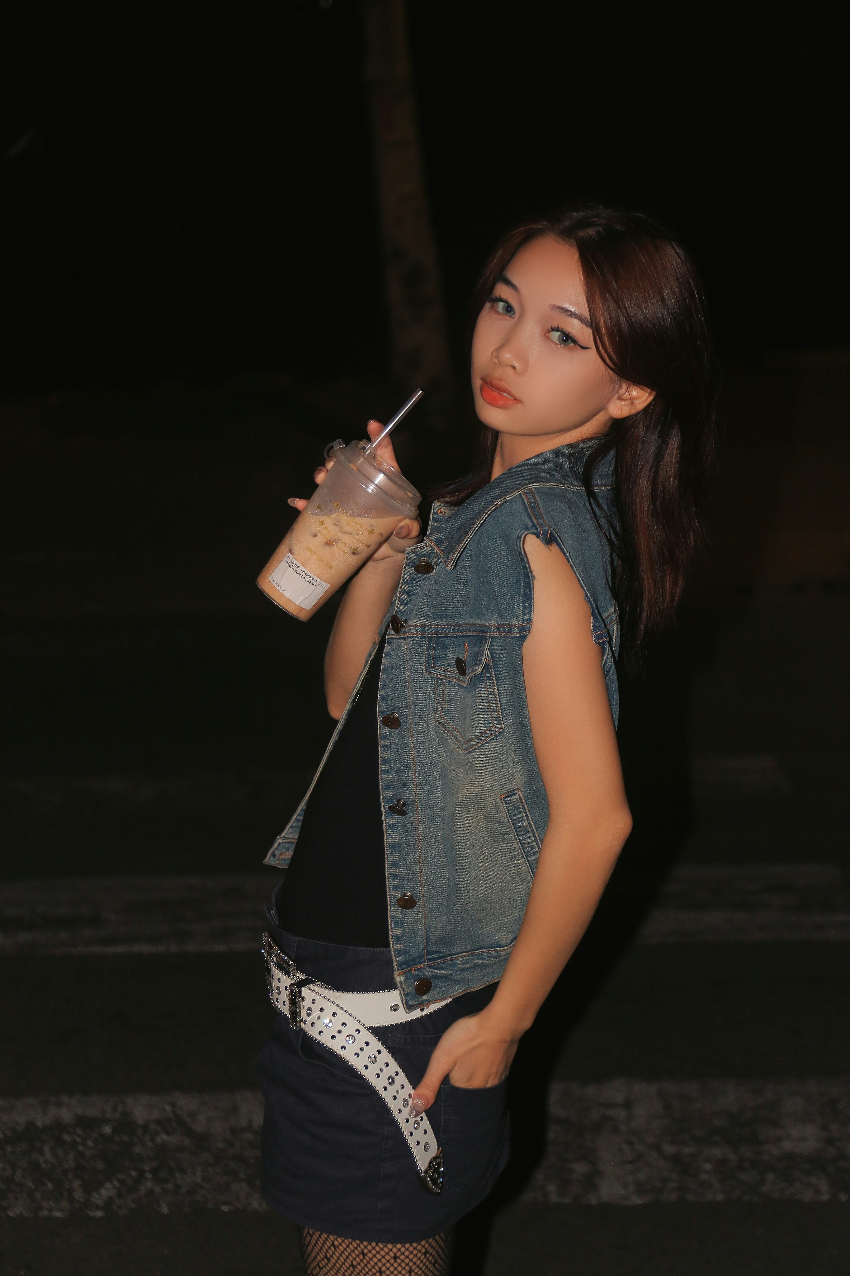 a young woman holding a drink in her hand