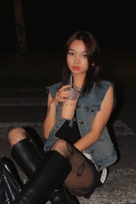 a woman sitting on the ground holding a drink