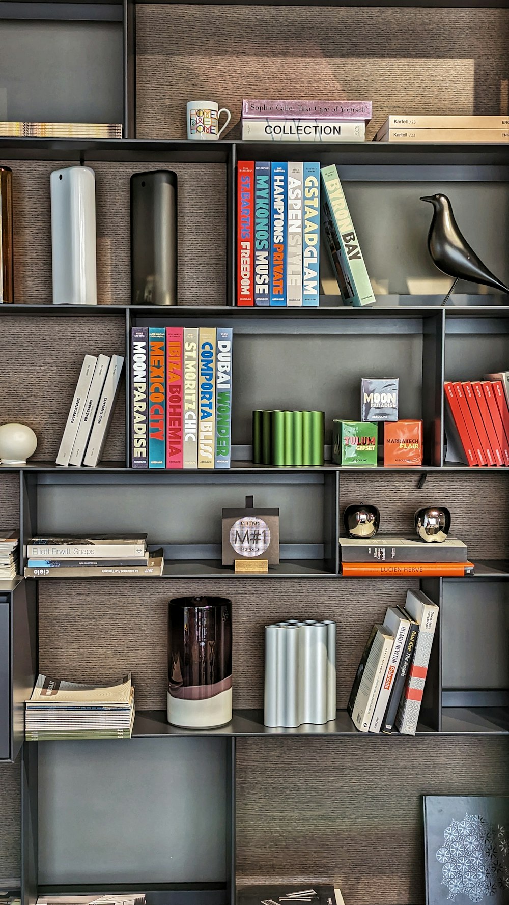 a bookshelf filled with lots of books on top of a wooden floor