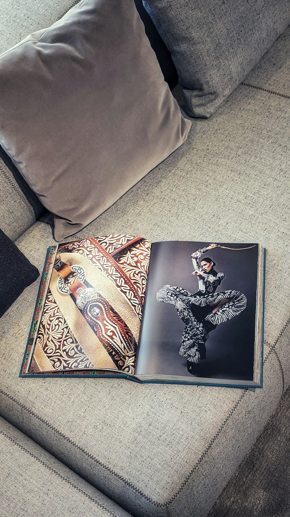 a book is laying on a couch with pillows