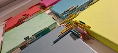 a bunch of different colored papers on a table