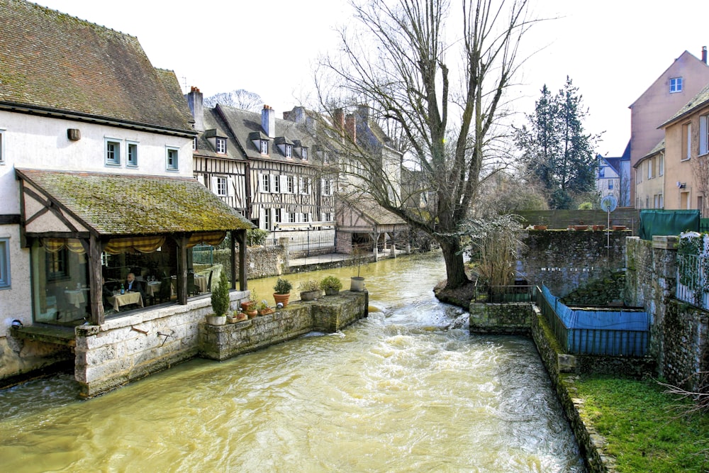 a river running through a small town next to tall buildings